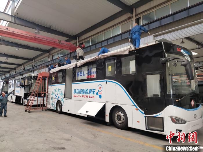 工人在组装5G智能移动核酸检测车车顶设备。 王鹏 摄 工人在组装5G智能移动核酸检测车车顶设备。 王鹏 摄